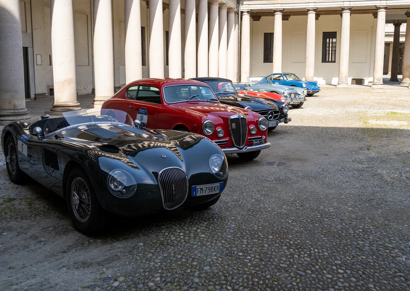 Auto d'epoca esposte in un cortile lastricato